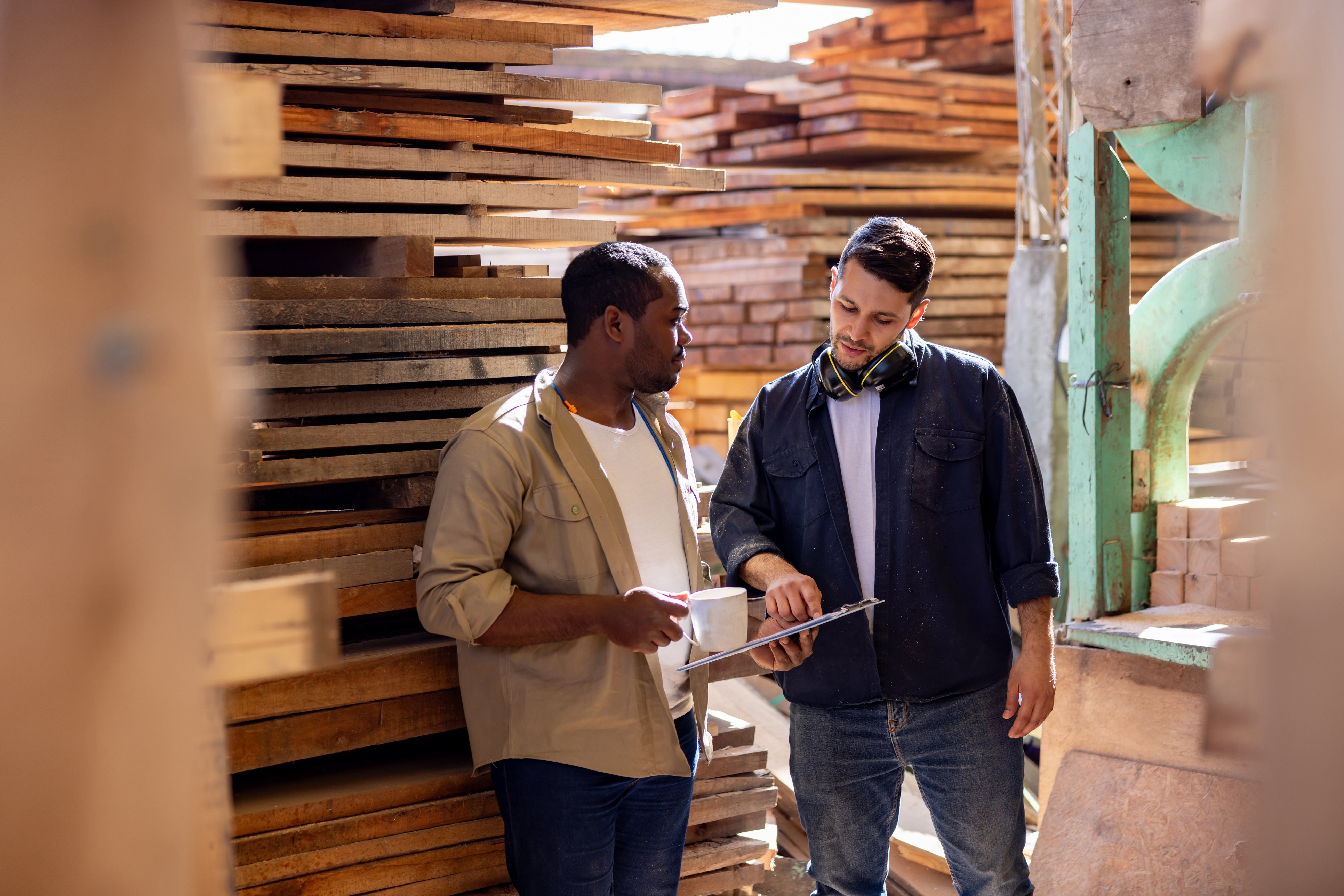 Image of 2 men discussing about something on a clipboard at a yard